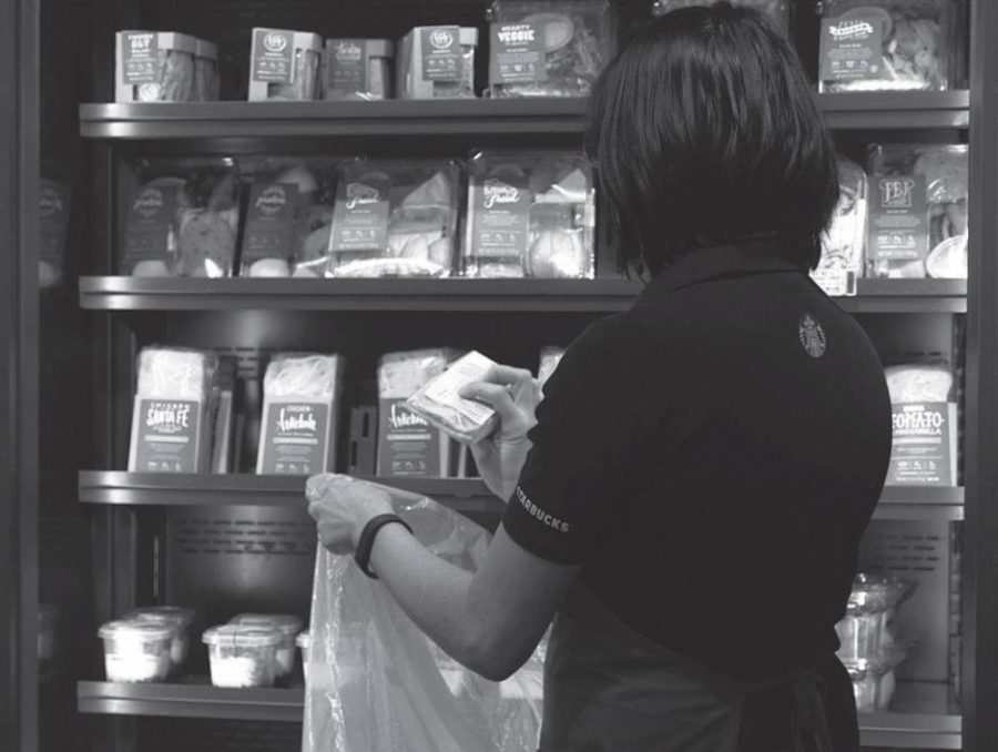 A Starbucks employee bags leftover food for the FoodShare program.