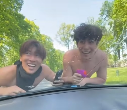 WCHS seniors Ryan You and Darian Tamami climb onto a car windshield during Senior Assassin.