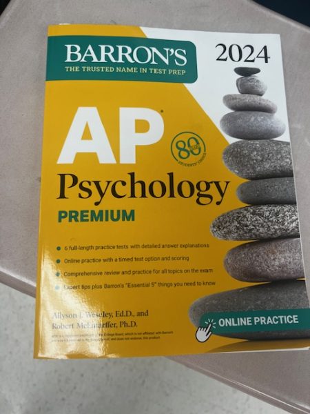One of the current AP Psychology test preparation books for 2024 AP Psychology students lies on the desk of Kanav Kachoria. Future AP Psychology test preparation books will have to change their content to meet the new curriculum of the course issued by College Board, in future school years.