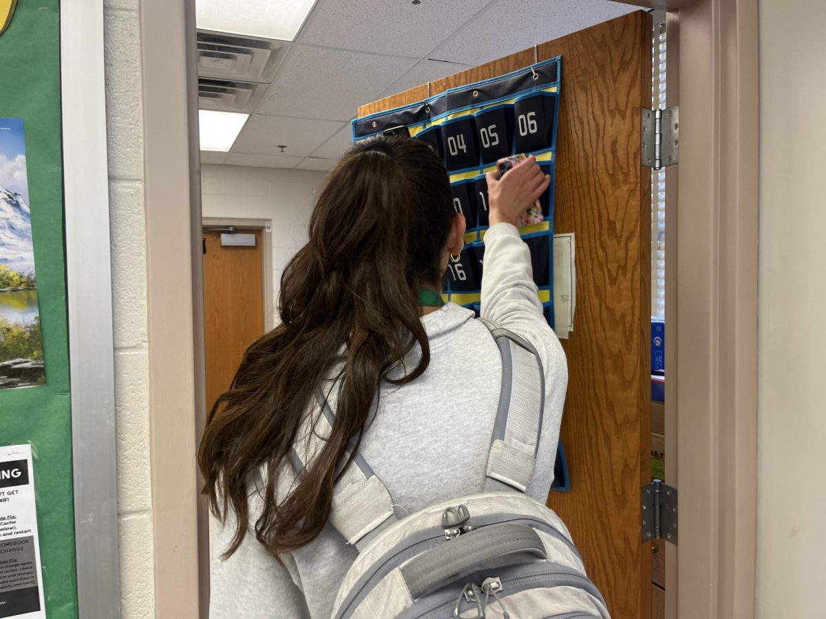 WCHS junior Lia Kudulko retrieves her phone from the blue cubby at the front of the classroom after finishing a double period of AP Biology. 