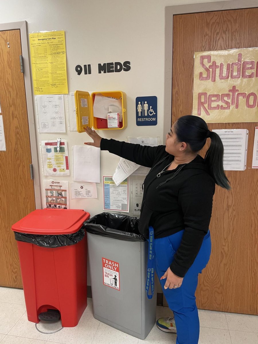 WCHS Nurse Ms. Joselyn Gonzalez opens the yellow cabinet where the healthroom stores Narcan in the case of an emergency. Narcan is stored alongside other "911 medication" used by healthroom staff until emergency services arrive.