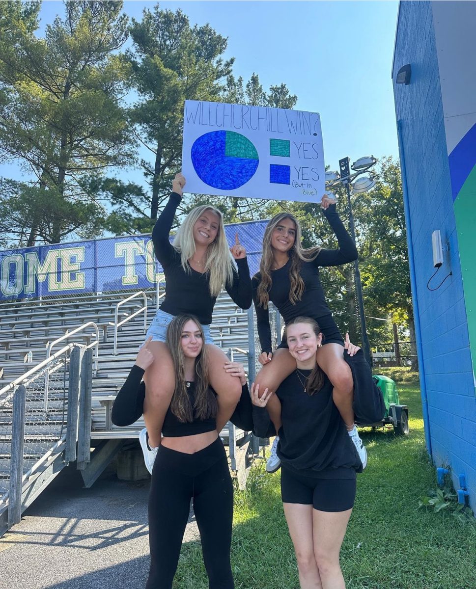 Four of the WCHS K9 members pose with a sign on the day of the black-out Wootton game. The spirited black-out and sign making preparation has become a tradition for the K9s leading up to the rival Wootton game. 