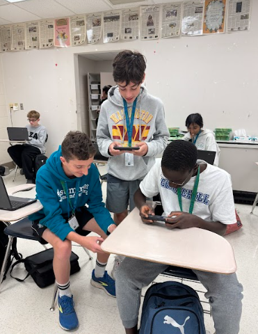 WCHS freshmen Xavier Reyman, Cooper Glazer and Malaki Kagwa interact while playing an online mobile game. 