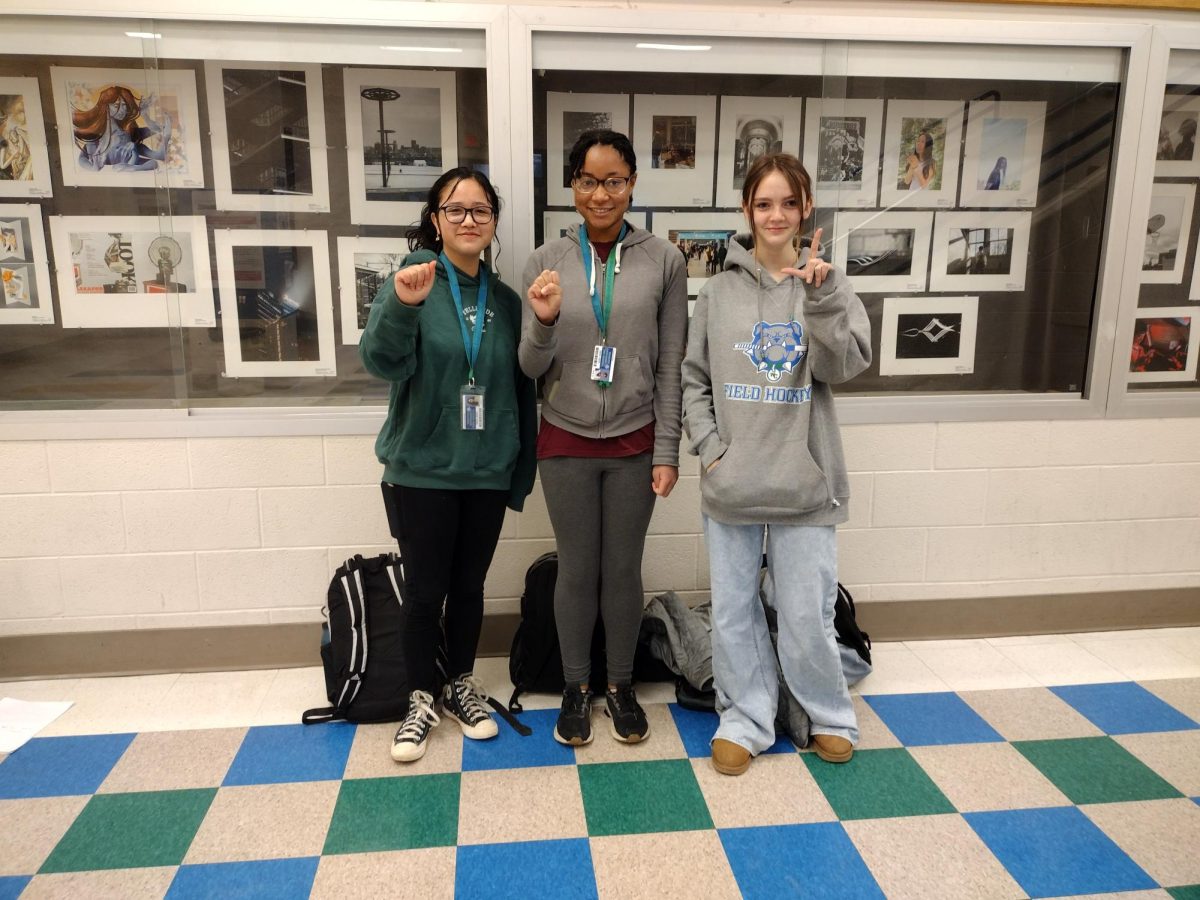 WCHS sophomore Adaora Holder shares her ASL knowledge with her friends. Each signing a letter, they form the word ASL. WCHS ASL courses give students the opportunity to communicate with those around them in new ways.