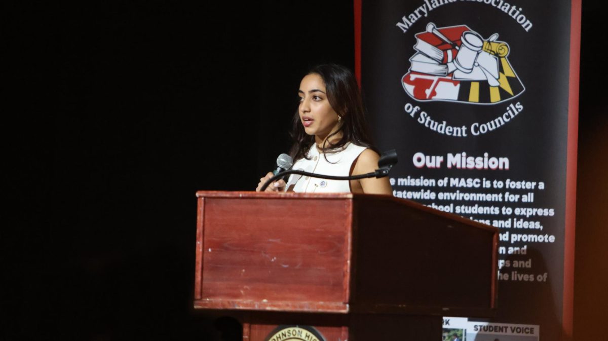 Zaria Naqvi poses in front of the Maryland Association of Student Councils (MASC), at a winter student leadership conference, after advocating for school safety and student representation in her speech for Maryland Student Member of the board.